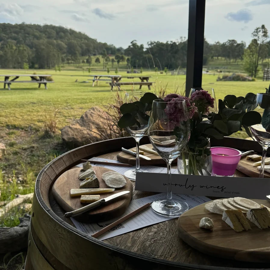A wine and cheese tasting set up on a wine barrel looking out over the paddocks at Broke