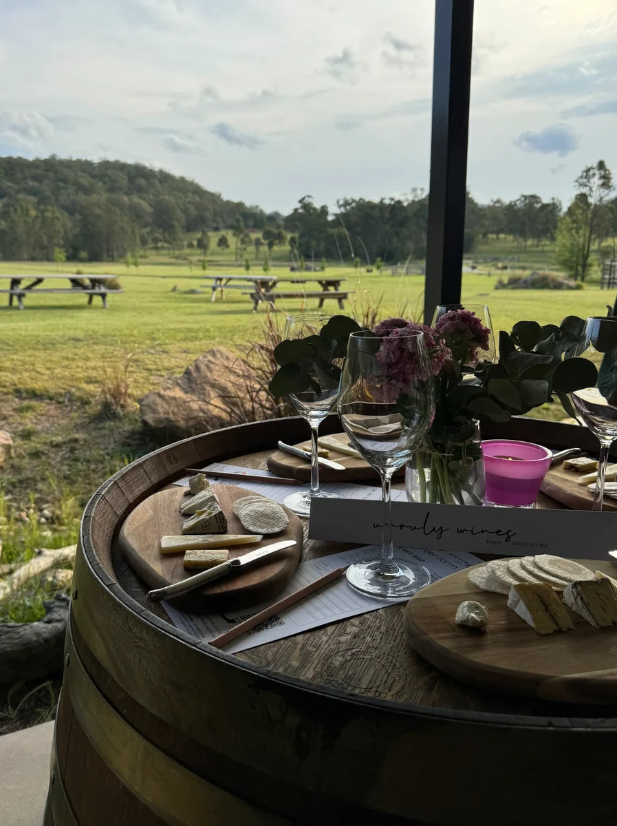 A wine and cheese tasting set up on a wine barrel looking out over the paddocks at Broke